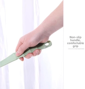 Close-up of the light green non-slip ergonomic handle with hanging hole on a bath brush