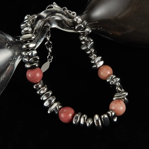Detailed close-up of pink volcanic stone and silver bamboo steel chain link bracelet