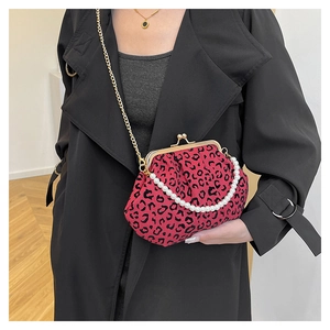 Detail of vintage leopard print shell bag with pearl handle and golden chain strap