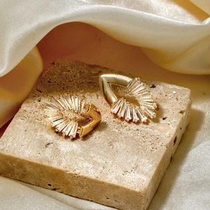 Elegant gold fan-shaped stud earrings with clear rectangular zircons on stone base