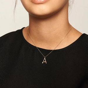 Close-up of a gold S925 silver necklace with a colorful zircon letter A pendant