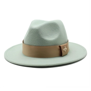 Detail of mint green wool fedora with khaki satin ribbon and golden bee brooch