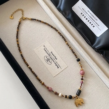 Detailed close-up of handmade beaded necklace with golden elephant pendant in a gift box