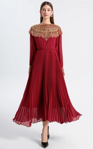 Detail of burgundy pleated maxi dress showing gold sequin bead embroidery on the neckline