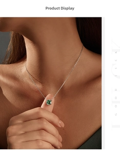 Close-up of a model wearing a minimalist silver necklace with a green round gemstone
