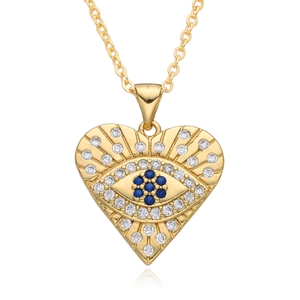 Close-up of golden heart pendant with blue evil eye detail and white zircon inlay