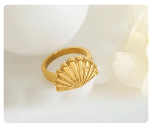 Macro shot of polished gold-plated stainless steel scallop shell ring with fine textures