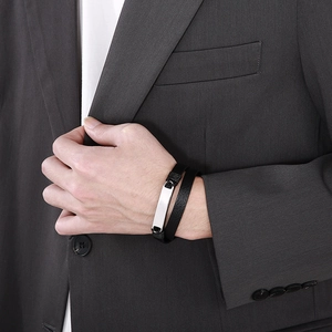 Man wearing a double-layer braided black leather bracelet with a silver stainless steel plate
