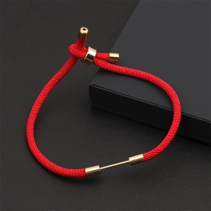 Detail of red nylon braided rope bracelet with adjustable gold-plated metallic buckle