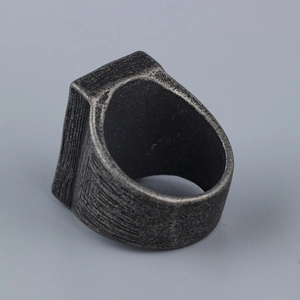 Close-up of vintage industrial cross ring with heavy brushed metal texture for men