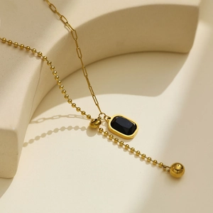 Detail view of vintage gold necklace with black zircon pendant and mixed chain links