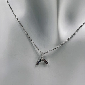 Macro detail of silver rainbow pendant with colorful micro-set zircons on mannequin