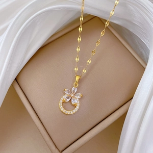 Detailed view of gold flower pendant with clear cubic zirconia on a chic silk background