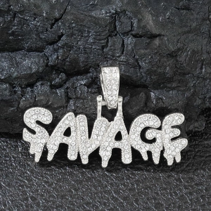 Close-up of silver savage hip-hop pendant with iced-out crystals on dark stone texture