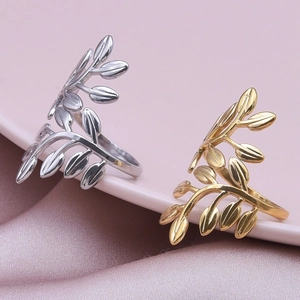 Minimalist adjustable leaf ring set in gold and silver finish on silk fabric