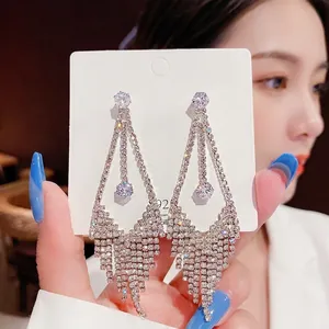 Detailed close-up of long silver tassel earrings with shimmering crystals on S925 card