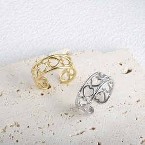 Detailed view of hollow heart patterns on adjustable minimalist stainless steel rings