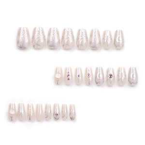 Press-on nail set with nude pink base, silver star and moon patterns, and rhinestone accents