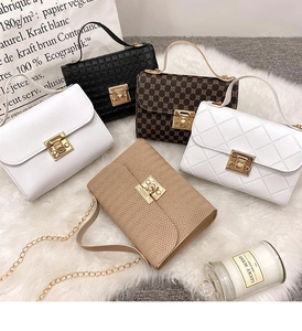 Detailed display of five colorful textured crossbody bags with gold clasps on plush rug