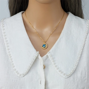 Golden galaxy necklace with a blue gemstone pendant on a female model's neck