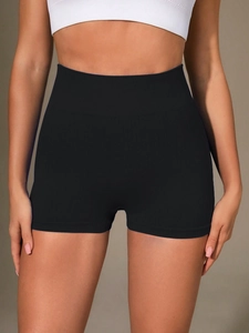 Detail of high waisted seamless ribbed black yoga shorts with tummy control texture