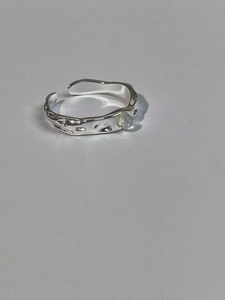 Macro shot of silver S925 moonstone ring with irregular lava texture and open adjustable band