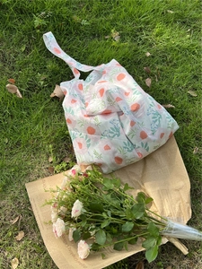 French pastoral style tote bag with pink rose prints on green grass with vintage props