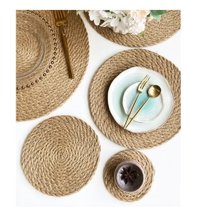 Set of round jute placemats in various sizes with natural fiber texture on white table