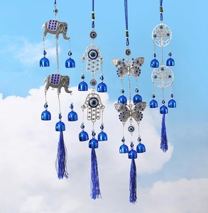 Blue Turkish Evil Eye wind chimes with Hamsa and Tree of Life charms against sky