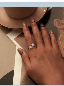 Close-up of S925 sterling silver floral open ring with blue flower on hand