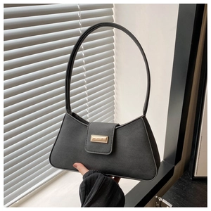 Detail of minimalist black leather baguette bag with metal buckle on the shoulder strap