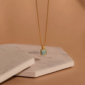 Detail of a square blue opal pendant on a delicate gold chain with a macro view texture