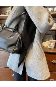 Detail of grey herringbone wool coat with black scarf and matching leather handbag