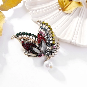 Broche papillon vintage dorée avec strass colorés et une perle blanche suspendue