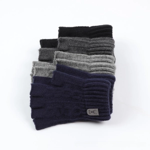 Detail of multi-color knitted fingerless gloves with ribbed cuffs and deer logo tags