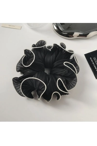 Detail shot of a large black organza scrunchie with elegant white stitched edges