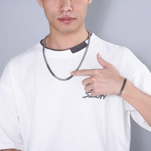 Silver Cuban link chain necklace and bracelet set displayed on a male model for styling