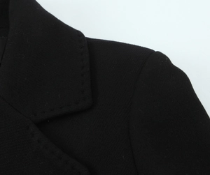 Detailed close-up of a black wool coat collar and shoulder with visible fabric texture