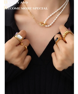 Detail of 18k gold plated necklace with freshwater pearls and stacked rings set