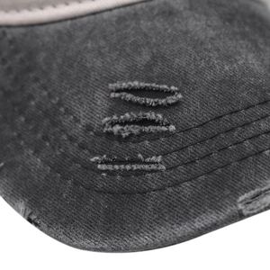 Macro detail of washed cotton baseball cap with distressed edges and denim stitching