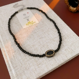 Detail of vintage French black bead necklace with oval crystal pendant and bronze frame