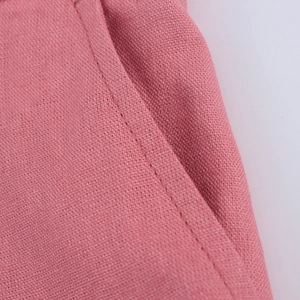 Detail view of pink cotton linen fabric texture and stitching on a women vest set