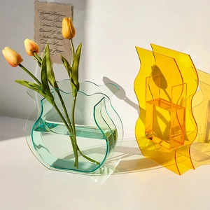 Minimalist acrylic wavy flower vases in blue and orange with yellow tulips decor