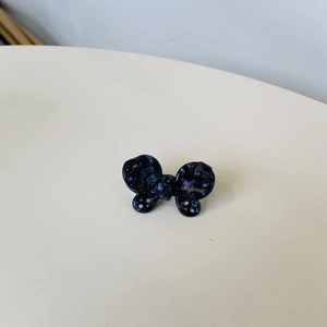 Detail of blue acetate butterfly hair clip with galaxy texture and subtle rhinestones