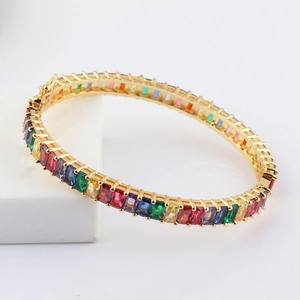 Macro view of gold bracelet featuring rainbow gradient rectangular cubic zirconia inlay