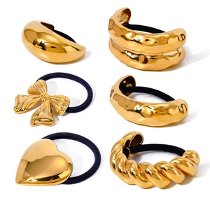 Set of 6 gold stainless steel hair ties featuring heart and bow designs on white background