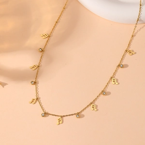Macro shot of gold music note pendant with round rhinestone on a fine stainless steel chain