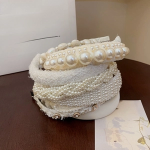 Detailed view of French vintage tweed hairbands with elegant pearls on dark wood