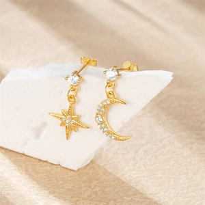 Macro shot of S925 sterling silver gold earrings with star and moon zircon studs