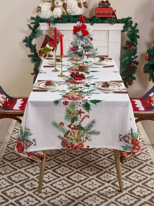 Primer plano de mantel navideño con estampados festivos de pinos y adornos de Navidad